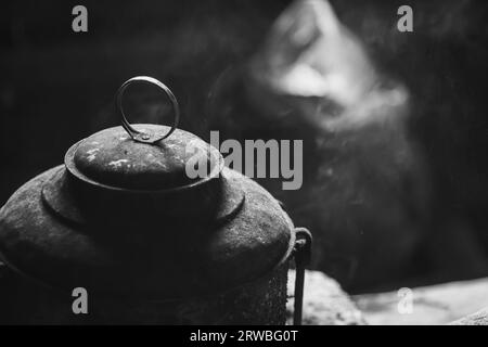 Un pot avec un couvercle noirci par le feu. Ustensile de cuisson pour préparer des repas sur un feu. La couleur noire de la batterie de cuisine est due à la suie. Photo de haute qualité Banque D'Images