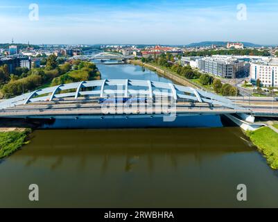 Cracovie, Pologne. Pont suspendu Kotlarski avec autoroute, piste cyclable, tramway et tramway bleu sur la Vistule. Autres ponts et vieille ville avec Banque D'Images