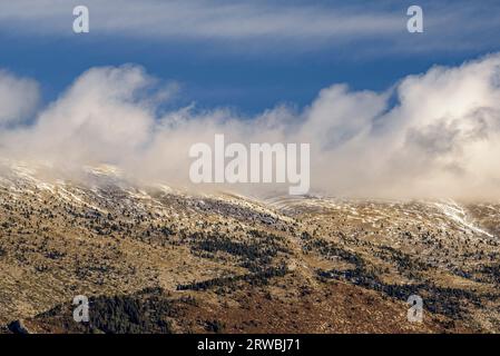 Face sud de la chaîne de montagnes Serra del Cadí avec un peu de neige et de nuages bas, vue depuis le col du Coll de Port. Alt Urgell Lleida, Catalogne Espagne Banque D'Images