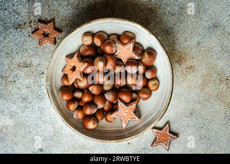 Du dessus de l'assiette de tas de châtaignes avec savoureux biscuits de Noël placés sur la table dans le fond gris béton Banque D'Images