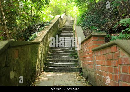 Escalier avec des marches tordues mène vers le haut dans la luminosité Banque D'Images