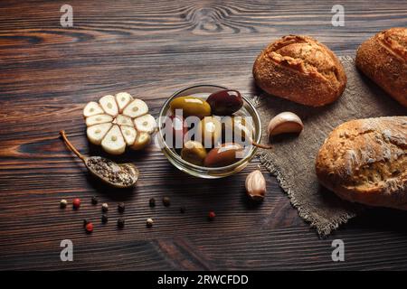 Un ensemble d'olives à l'ail poivre ail sur une table en bois brun Banque D'Images