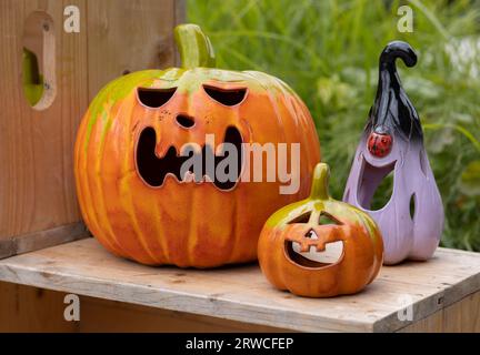 Deux citrouilles en céramique et une aubergine se tiennent sur l'étagère d'une foire de rue rurale à la veille de la célébration d'Halloween Banque D'Images