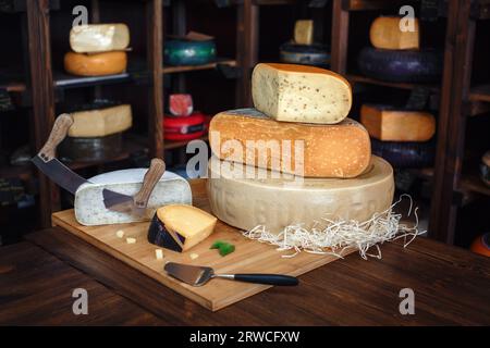Jeu de fromage têtes de fromage étagères avec des fromages de différentes sortes Accessoires fromage Basil, dégustation Banque D'Images