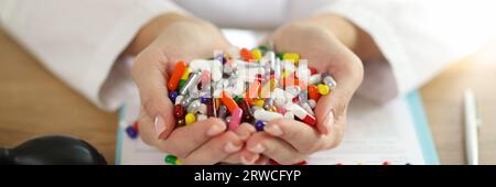 Le médecin féminin tient un tas de différentes pilules médicales dans ses mains. Banque D'Images