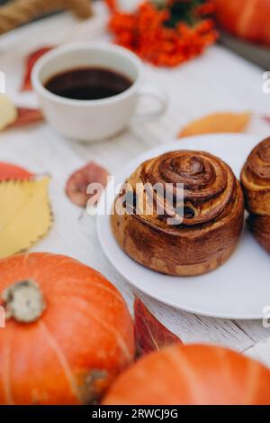 pain, pâtisserie sur plateau avec boisson et décoration d'automne : feuilles jaunes tombées et citrouilles. ambiance automnale Banque D'Images