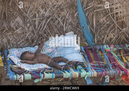 14 février 2023, ville de Chennai, Inde : un enfant nomade est allongé sur un lit à l'intérieur d'un abri temporaire. Banque D'Images