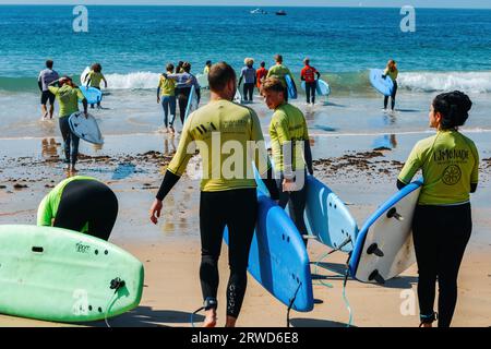 Groupe de jeunes surfeurs sur la plage de Carcavelos près de Lisbonne, Portugal pendant une journée d'été Banque D'Images