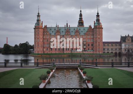 Château de Frederiksborg à Hillerød Danemark, vue depuis le jardin baroque au coucher du soleil avec des nuages sombres Banque D'Images