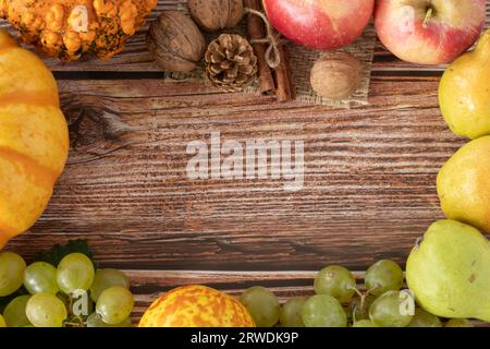Fond d'automne avec citrouille, pommes, raisins et divers fruits d'automne sur la table en bois. Espace de copie. Vue de dessus. Banque D'Images