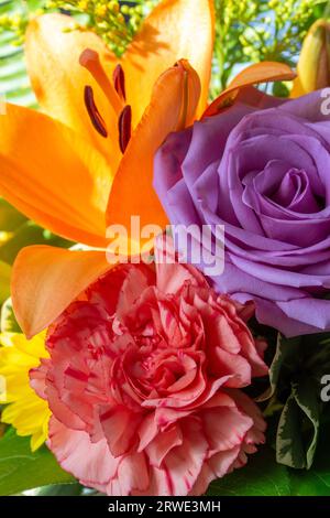 Macro texture arrière-plan de fleurs lumineuses fraîches dans un arrangement de fleuriste intérieur, mettant en vedette une rose, œillet, lis, et chrysanthème Banque D'Images