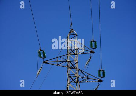 Pylône haute tension avec trois bobines, fond bleu ciel Banque D'Images