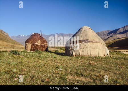 Villes nomades avec des yourtes sur les prairies vertes au Kirghizstan Banque D'Images