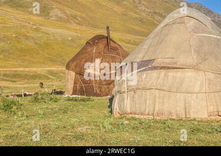 Villes nomades avec des yourtes sur les prairies vertes au Kirghizstan Banque D'Images