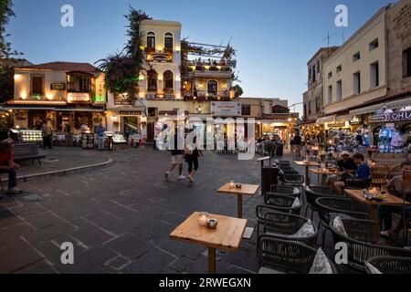 Cafés de rue et petits magasins sur Platia Ippokratou la nuit, la vieille ville de Rhodes, Rhodes, Grèce Banque D'Images