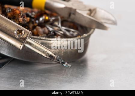 Fer à souder avec étain, colophane et pinces sur la table d'atelier Banque D'Images