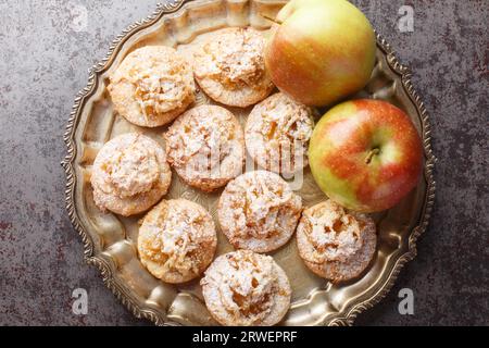 Biscuits garnis de confiture de pommes et saupoudrés de sucre en poudre gros plan dans une assiette sur la table. Vue supérieure horizontale par le haut Banque D'Images