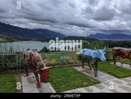 GRUYÈRE, SUISSE - 5 AOÛT 2023 : vaches peintes au Motel de la Gruyère, symbole suisse et art contemporain sur le paysage du lac Banque D'Images