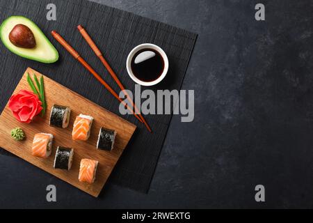 Ensemble de sushi et rouleaux de maki avec avocat tranché sur la table en pierre. Vue de dessus. Banque D'Images