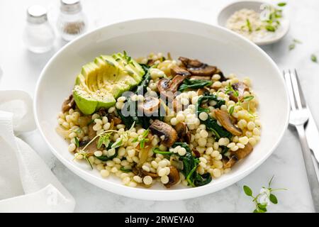 Couscous à l'avocat, épinards et champignons sautés à l'oignon Banque D'Images