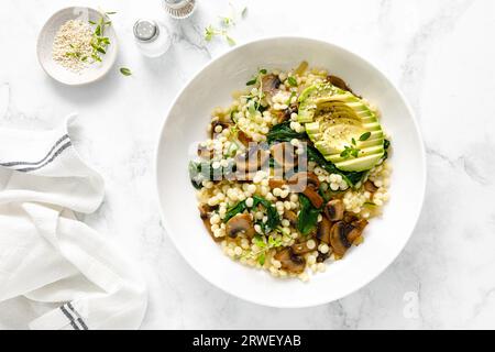 Couscous à l'avocat, épinards et champignons sautés à l'oignon, vue de dessus Banque D'Images