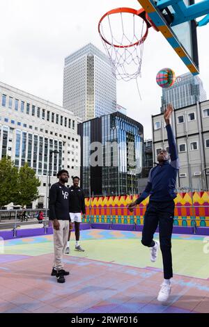 UTILISATION ÉDITORIALE SEULE l'équipe de basket-ball des Lions de Londres joue un match avec des gens de la communauté locale sur le terrain de basket-ball de Bank Street alors qu'elle collabore avec Canary Wharf Group pour relancer le terrain, conçu par l'artiste britannique Yinka Illori et offrir des séances d'entraînement gratuites aux enfants, adolescents, et les employés de bureau sur le domaine. Date d'émission : mardi 19 septembre 2023. Banque D'Images