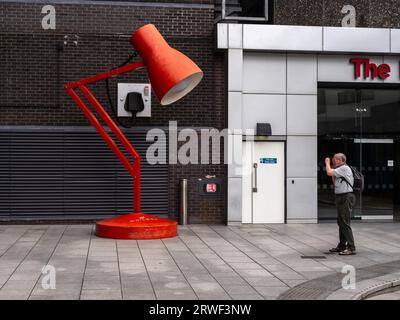 Œuvre d'art sous la forme d'une lampe de bureau rouge géante à l'entrée du bâtiment The Mailbox, Birmingham, Royaume-Uni Banque D'Images