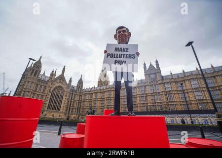 Londres Royaume-Uni. 19 septembre 2023 . Un mannequin portant une tête géante du Premier ministre Rishi Sunak sur un baril de pétrole lors d'une manifestation d'Oxfam devant le Parlement dans le cadre de la campagne Make polluers Pay, Oxfam appelle à taxer davantage les géants du pétrole et du gaz afin de soutenir les communautés touchées par le changement climatique. Crédit amer ghazzal/Alamy Live News Banque D'Images