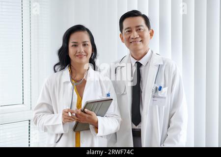 Portrait de médecins avec tablette ordinateur debout dans le bureau de la clinique médicale Banque D'Images