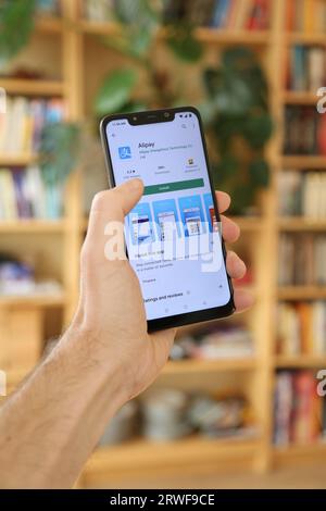 VARSOVIE, POLOGNE - 29 JANVIER 2021 : utilisateur installant l'application de paiement en ligne Alipay chinoise sur un système d'exploitation Android, smartphone de marque Xiaomi. Banque D'Images