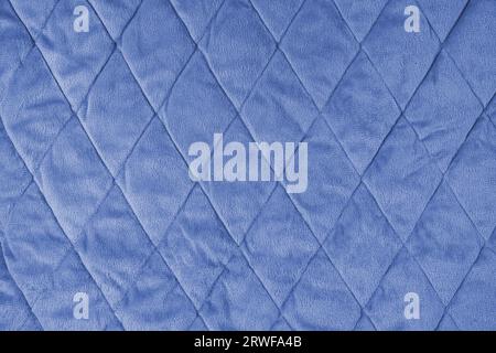 Fond de tissu velours matelassé. Couverture de texture bleue ou veste bouffante, stiched avec motif de diamant, surface froissée douce, textile écrasé Banque D'Images