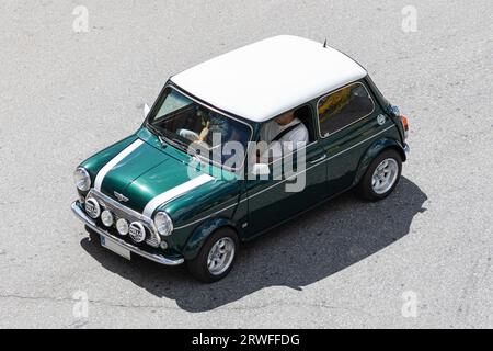 Galice, Espagne ; 27 août 2023 : vue en grand angle d'une voiture de collection Morris Mini Cooper conduisant sur une route Banque D'Images