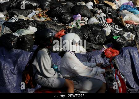 Yogyakarta, Indonésie. 19 septembre 2023. 19 septembre 2023, Yogyakarta, région spéciale de Yogyakarta, Indonésie : les motocyclistes passent près de tas de déchets à Yogyakarta. L’accumulation de déchets en plusieurs points de Yogyakarta est due à la réouverture du site intégré d’élimination des déchets de Piyungan (TPST) sur une base limitée avec un quota de 180 tonnes par jour. (Image de crédit : © Angga Budhiyanto/ZUMA Press Wire) USAGE ÉDITORIAL SEULEMENT! Non destiné à UN USAGE commercial ! Crédit : ZUMA Press, Inc./Alamy Live News Banque D'Images