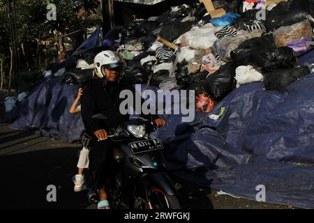 Yogyakarta, Indonésie. 19 septembre 2023. 19 septembre 2023, Yogyakarta, région spéciale de Yogyakarta, Indonésie : les motocyclistes passent près de tas de déchets à Yogyakarta. L’accumulation de déchets en plusieurs points de Yogyakarta est due à la réouverture du site intégré d’élimination des déchets de Piyungan (TPST) sur une base limitée avec un quota de 180 tonnes par jour. (Image de crédit : © Angga Budhiyanto/ZUMA Press Wire) USAGE ÉDITORIAL SEULEMENT! Non destiné à UN USAGE commercial ! Crédit : ZUMA Press, Inc./Alamy Live News Banque D'Images