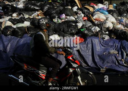 Yogyakarta, Indonésie. 19 septembre 2023. 19 septembre 2023, Yogyakarta, région spéciale de Yogyakarta, Indonésie : un motocycliste passe près de tas de déchets à Yogyakarta. L’accumulation de déchets en plusieurs points de Yogyakarta est due à la réouverture du site intégré d’élimination des déchets de Piyungan (TPST) sur une base limitée avec un quota de 180 tonnes par jour. (Image de crédit : © Angga Budhiyanto/ZUMA Press Wire) USAGE ÉDITORIAL SEULEMENT! Non destiné à UN USAGE commercial ! Crédit : ZUMA Press, Inc./Alamy Live News Banque D'Images