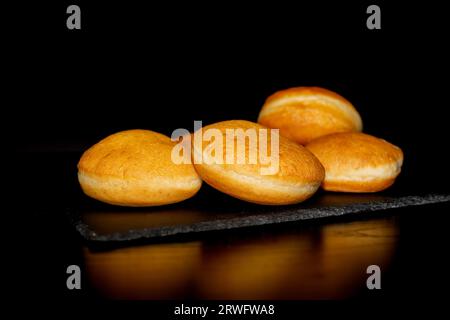 Krapfen traditionnel sans glaçure sur fond noir. Dessert d'Allemagne Banque D'Images