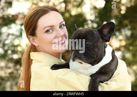 Portrait de femme heureuse avec mignon Bulldog français à l'extérieur Banque D'Images