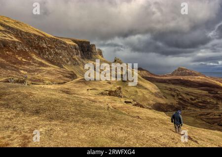 Un homme solitaire traverse le Quiraing sur l'île de Skye en Écosse Banque D'Images