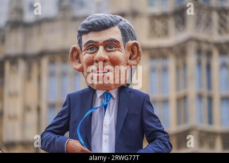 Londres Royaume-Uni. 19 septembre 2023 . Un mannequin portant la tête géante du Premier ministre Rishi Sunak avec une pancarte "Make polluers pay debout sur un baril de pétrole lors d'une manifestation d'Oxfam devant le Parlement dans le cadre de la campagne Make polluers Pay", Oxfam appelle à taxer davantage les géants du pétrole et du gaz afin de soutenir les communautés touchées par le changement climatique. Crédit amer ghazzal/Alamy Live News Banque D'Images