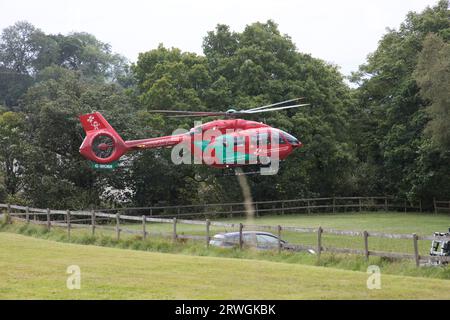 Red Wales Helicopter Ambulance atterrissant sur le terrain au National Whitewater Centre près de Bala North Wales Banque D'Images
