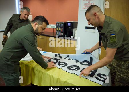 Staten Island, États-Unis. 19 septembre 2023. Le président ukrainien Volodymyr Zelenskyy, à gauche, signe un drapeau ukrainien lors d'une visite de militaires blessés en traitement et réadaptation à l'hôpital universitaire de Staten Island, le 19 septembre 2023 à Staten Island, New York, États-Unis. Crédit : Présidence ukrainienne/Bureau de presse présidentiel ukrainien/Alamy Live News Banque D'Images