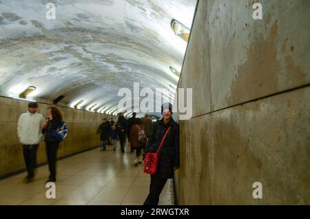 Une touriste féminine faisant une pause dans le tunnel souterrain piétonnier sous l'Arc de Triomphe, Paris, France. Accès au monument sous le rond-point Banque D'Images