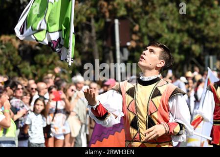 Badacsony, lac Balaton, Hongrie - 10 septembre 2023 - défilé de la fête des vendanges, jeune homme attrapant un drapeau Banque D'Images