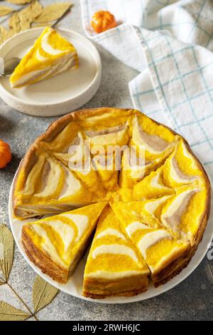 Dessert d'automne sain pour le petit déjeuner. Cocotte au fromage cottage à la citrouille « Zebra », cocotte rayée avec fromage, chocolat et citrouille sur le dos de pierre Banque D'Images