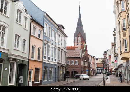 Flensburg, Allemagne - 10 février 2017 : vue sur la rue de la vieille ville de Flensburg avec l'église St.Mary sur un fond. Les gens ordinaires sont dans la rue Banque D'Images