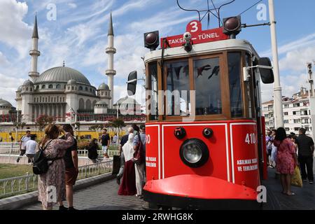 Tramway rouge sur Istiklal Caddesi (avenue de l'indépendance) avec Taksim Camii en arrière-plan, à Istanbul, Turquie Banque D'Images