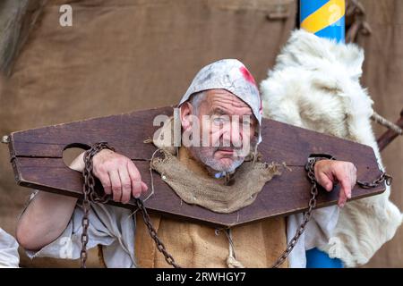 Saint Renan, France - juillet 16 2023 : Homme en vêtements médiévaux enchaîné au pilori pendant la fête médiévale de Saint Renan. Banque D'Images
