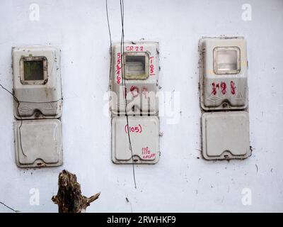 trois vieux compteurs électriques installés sur un mur blanc Banque D'Images