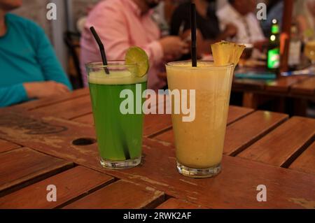 Gros plan d'ananas et de jus de citron vert sur table en bois Banque D'Images
