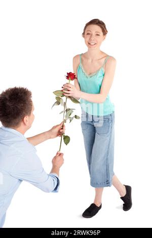 La remise de l'homme une rose rouge à un happy young woman isolated on white Banque D'Images